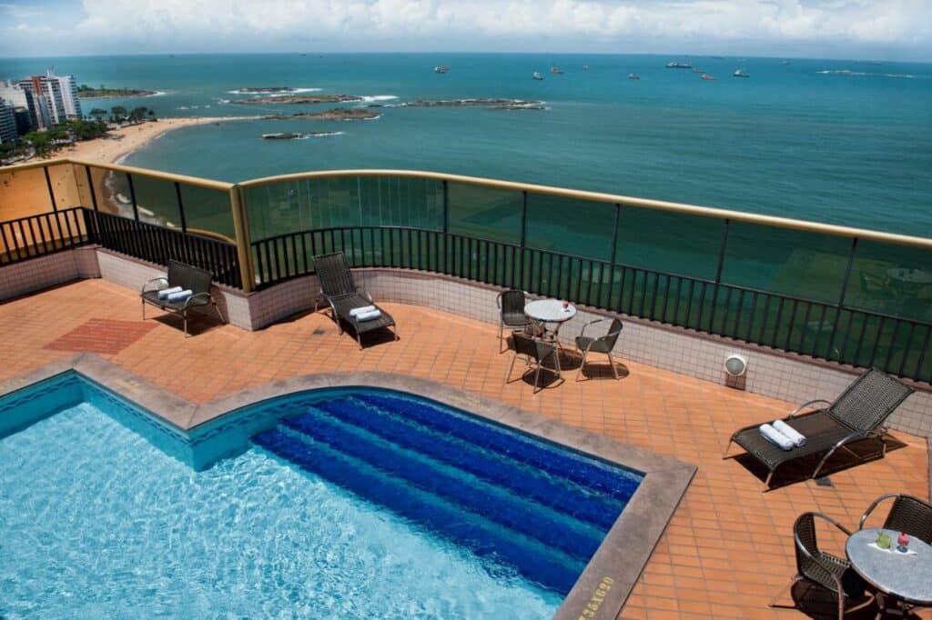 Piscina do Quality Suites Vila Velha com vista para o mar e a praia