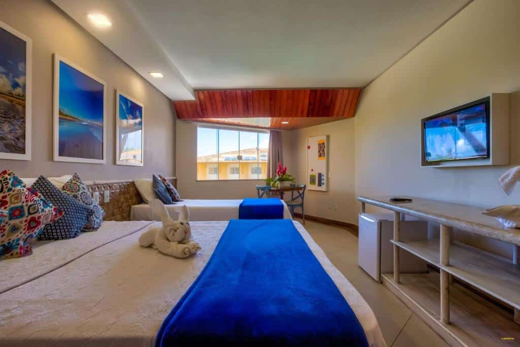 Quarto com cama de casal e cama de solteiro Hotel Aldeia da Praia.