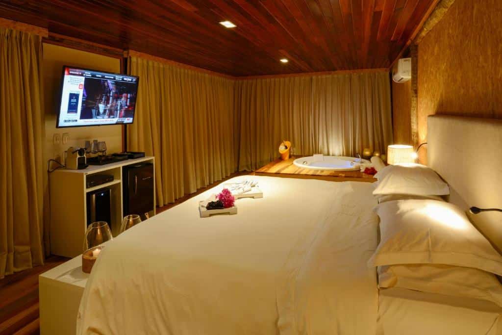 Vista do quarto BobZ Boutique Resort com cama,TV e banheira.