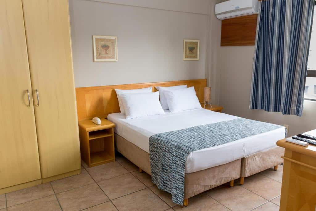 Quarto com cama de casal e guarda roupa na Maria Quitéria Hotel & Flat.