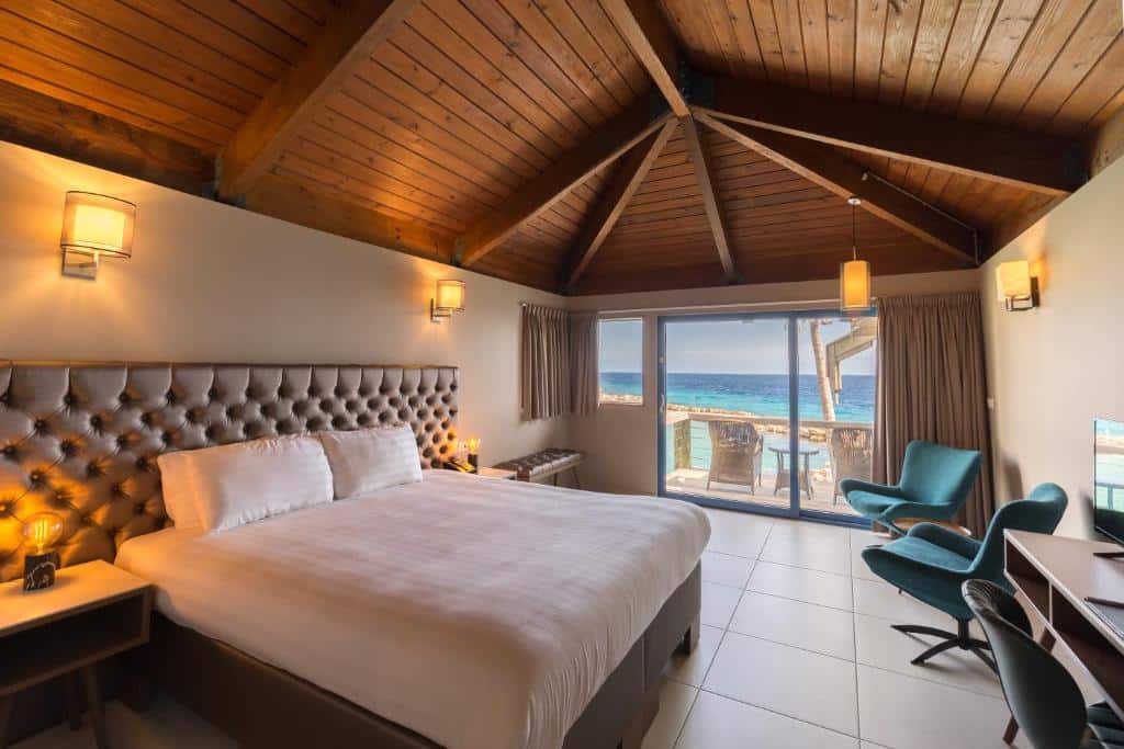 suíte do Curacao Avila Beach Hotel com uma varanda com vista para o mar e uma cama de casal