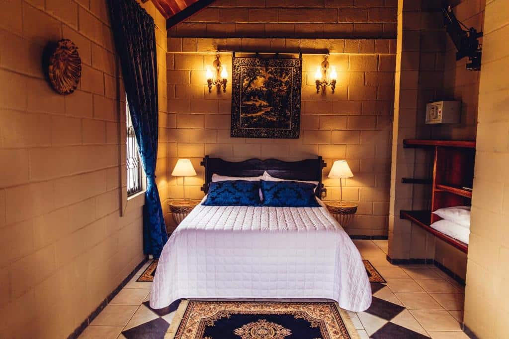 Quarto do Pousada Camelot Inn com uma decoração medieval, uma cama de casal, dois abajures, um armário de conceito aberto, para representar pousadas na Chapada dos Veadeiros