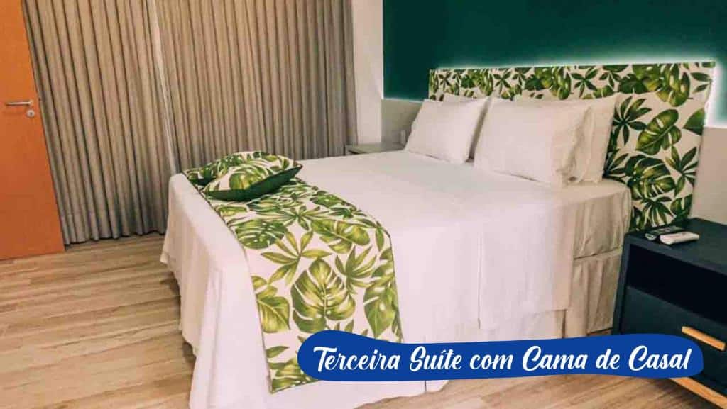 Quarto do Asenza Beach Resort All Inclusive com uma cama de casal, uma pequena cabeceira e uma janela com cortinas