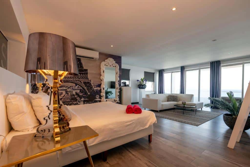 suíte com cama de casal, sala de estar e uma varanda com vista para o mar no Saint Tropez Boutique Hotel