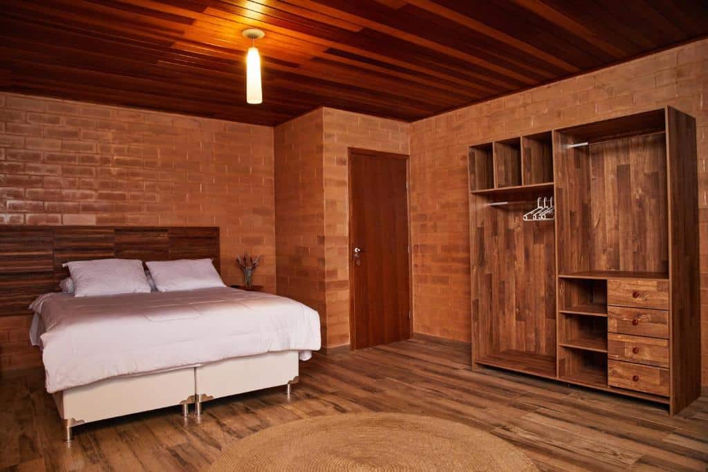 Quarto do Woodstock guesthouse com tudo em madeira, uma cama de casal, um armário conceito aberto e um tapete