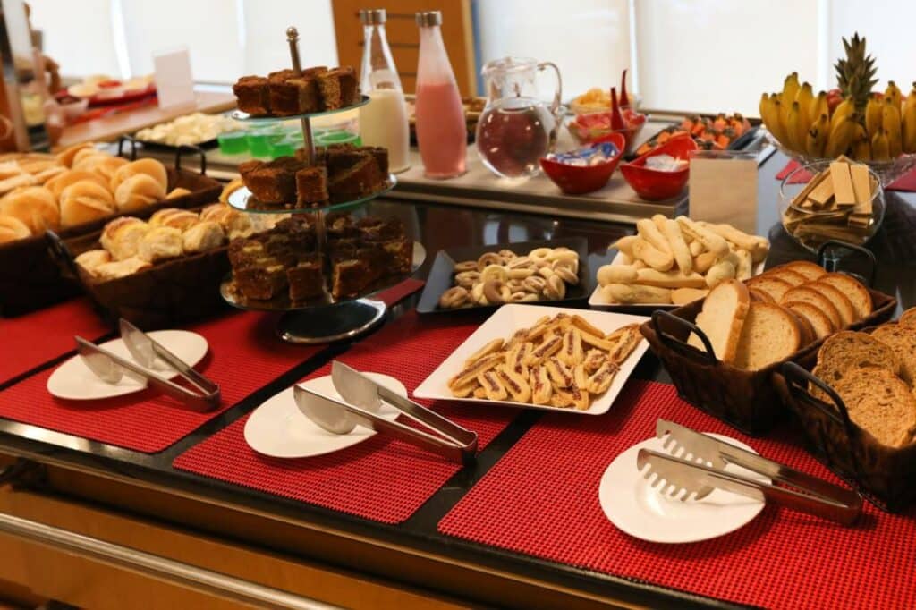 Restaurante do ibis Montes Claros Shopping com bolos, pães, sucos e frutas para os hóspedes
