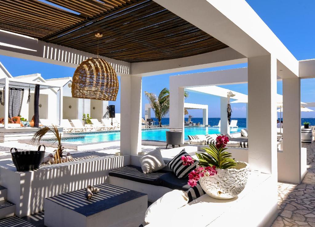 lounge compartilhado com varanda coberta e mobiliada e piscina em frente ao mar no Saint Tropez Boutique Hotel em Curaçao