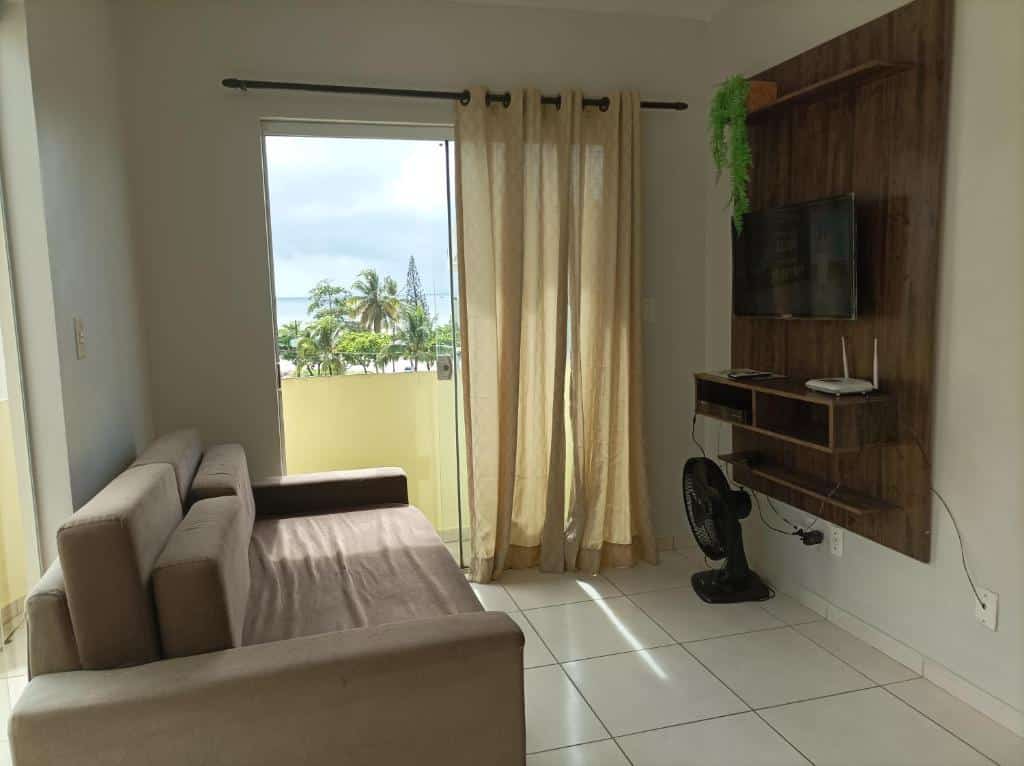Sala com sofá e Tv no Apartamento Mar Belo.