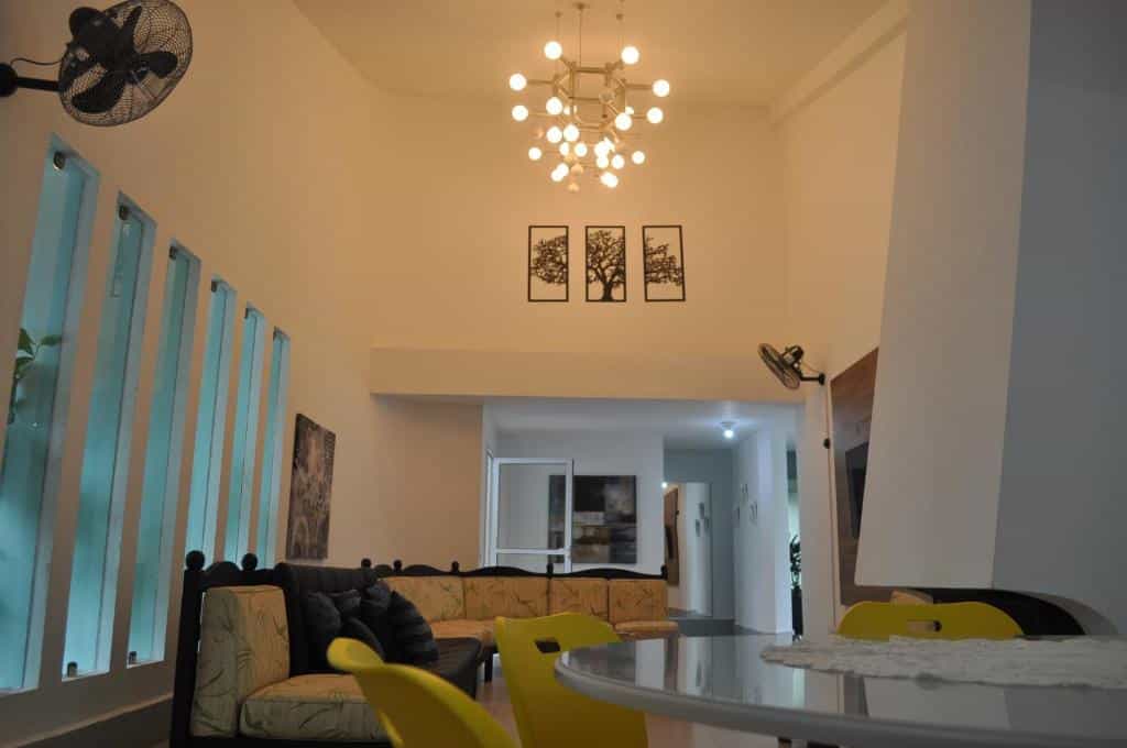 Sala de estar da Pousada Village Cozumel com um sofá, uma mesa de quatro lugares, ambiente arejado e decorado