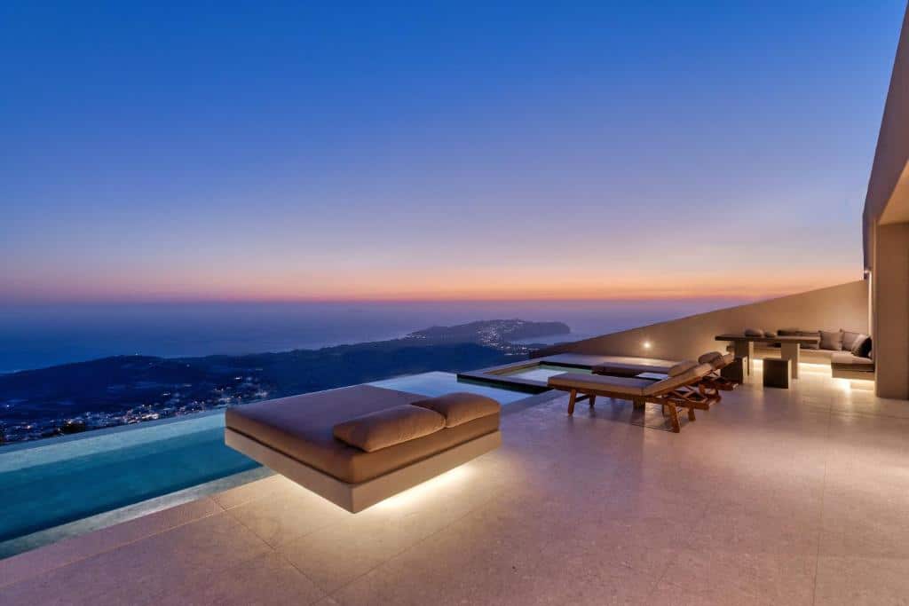 Varanda luxuosa com poltronas, piscina privativa e vista do mar do Santorini Sky, um dos hotéis em Santorini