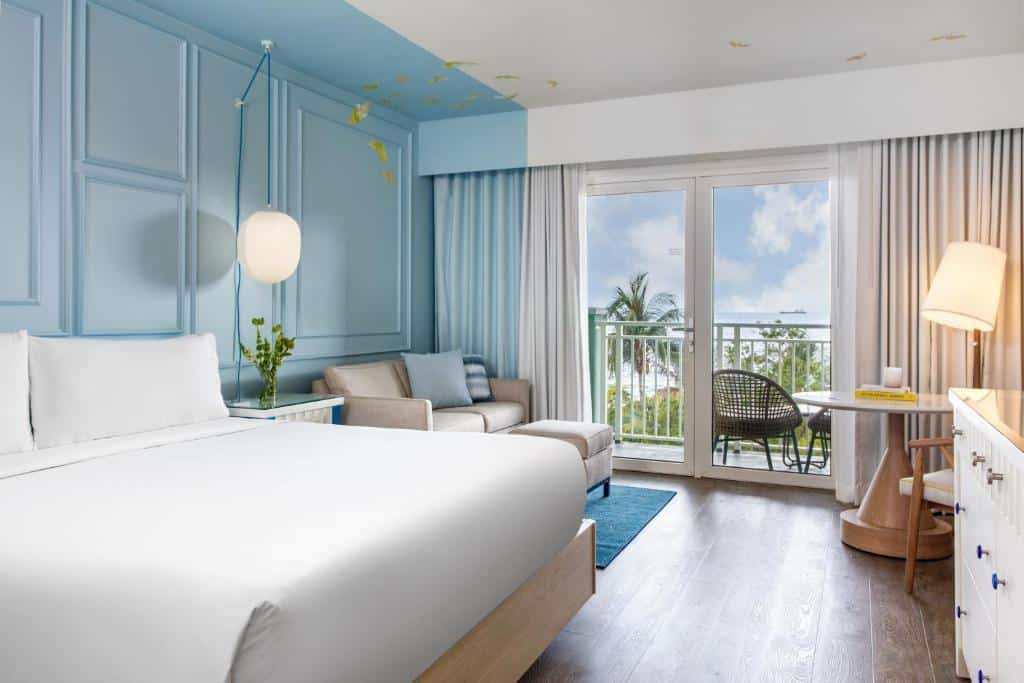 quarto com uma cama de casal, uma sala de estar e uma varanda com vista para o mar do Renaissance Wind Creek Curacao Resort