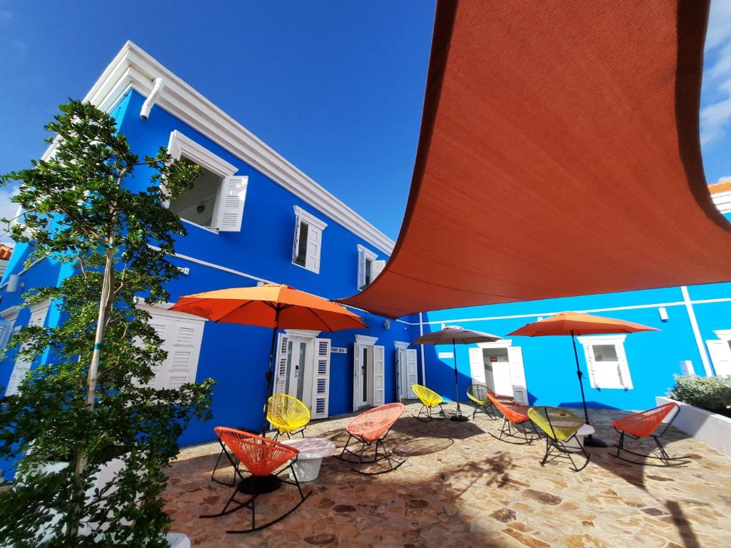 lounge compartilhado com mesas e cadeiras coloridas no The Freedom Hotel em Curaçao