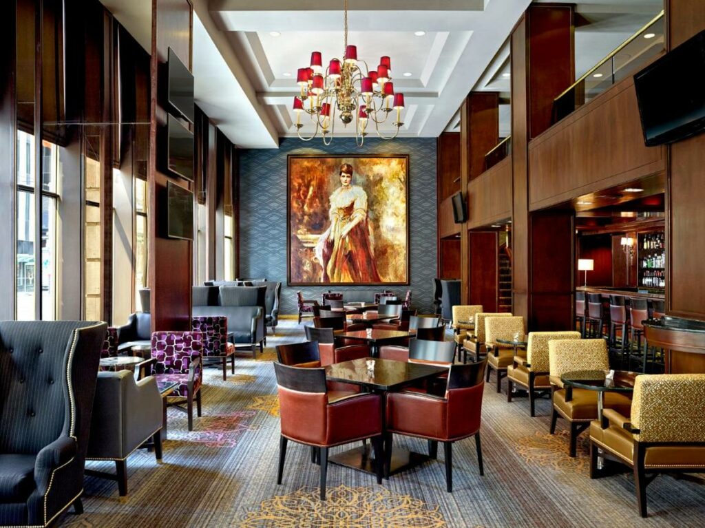 Restaurante do The Omni King Edward Hotel com tudo decorado em vermelho, dourado e madeira