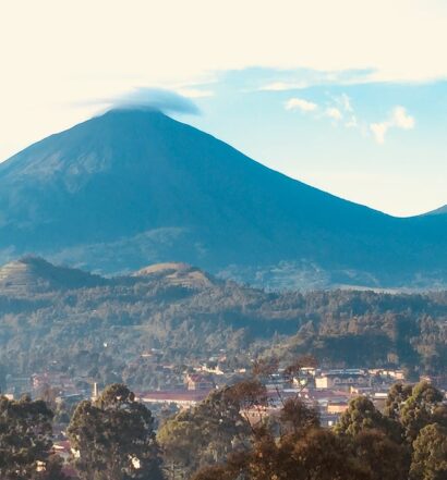 duas montanhas ao fundo de vegetações, o Vulcão Gahinga que pode ser visitado com o seguro viagem Ruanda