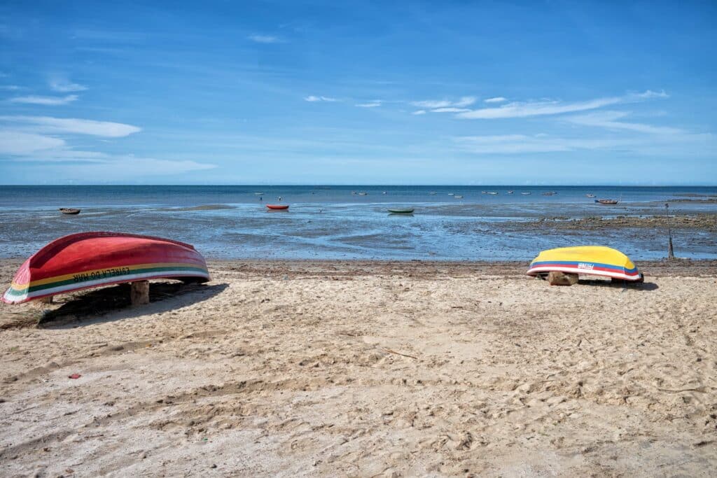 praia com dois barcos virados para baixo na areia e com o mar ao fundo em Cajueiro da Praia, Piauí