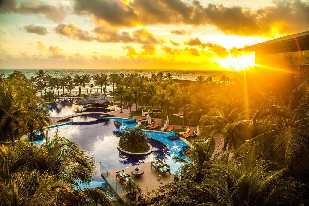 Área de piscinas beira-mar, com um lindo pôr do sol, do Carmel Cumbuco, um dos Resorts para o Réveillon