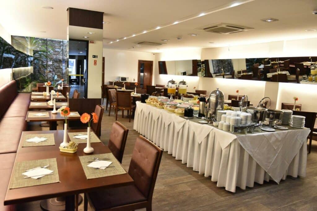 Restaurante do Cordilheira Hotel com mesas e sofás para se sentar e, ao centro, o self-service