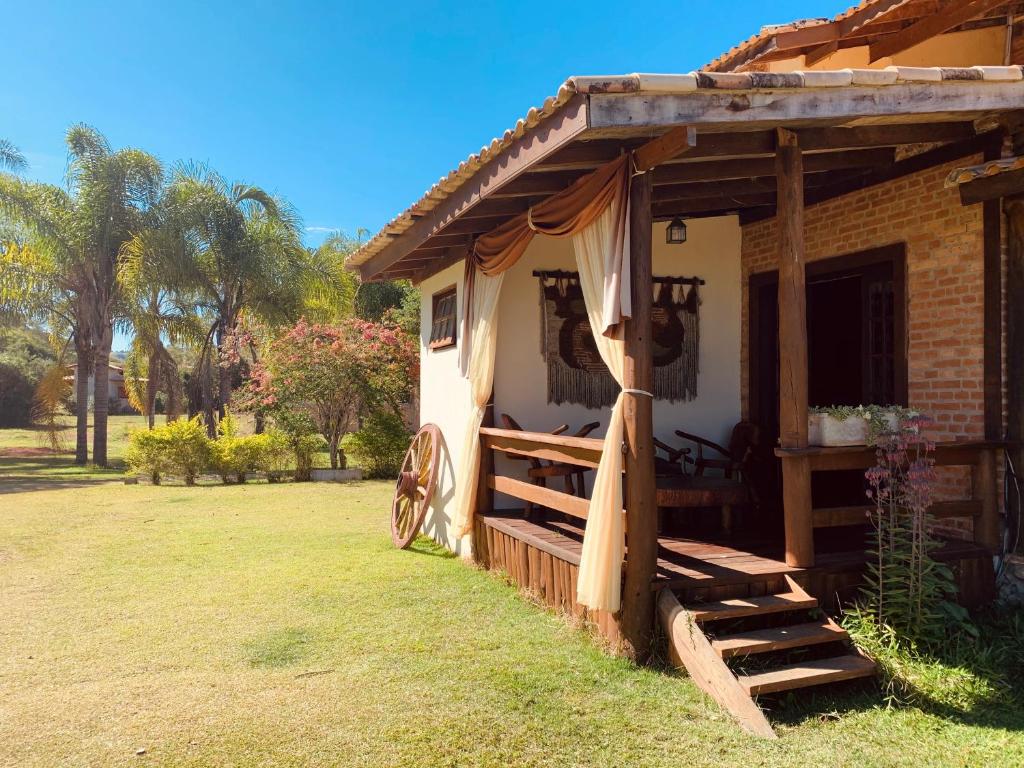 fachada da Recanto Roça Grande com escadinha e gramado, com portas e janelas de madeira, sendo uma das opções de pousadas na Serra da Bocaina