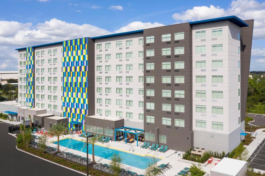 fachada do Tru By Hilton Orlando Convention Center com prédios imponentes em tons de cinza e azul com uma piscina retangular bem grande