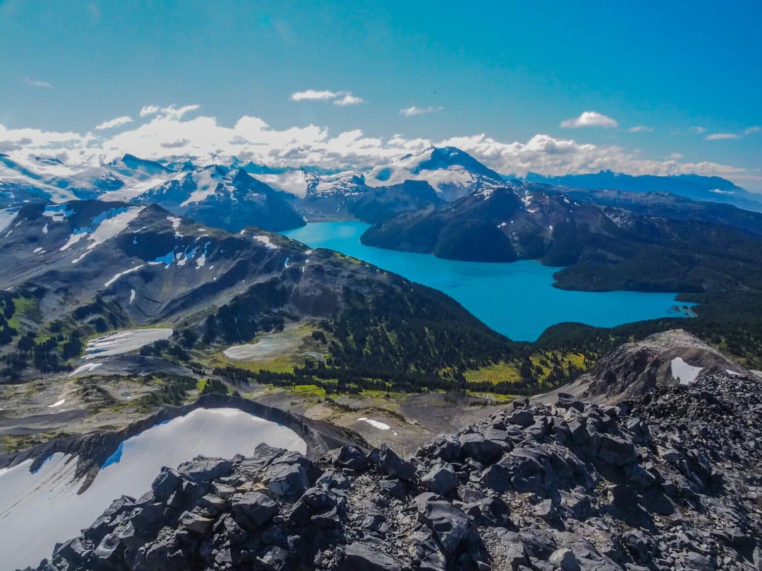 Lago com águas azuis cristalinas cercado por natureza exuberante para representar o seguro viagem Whistler.