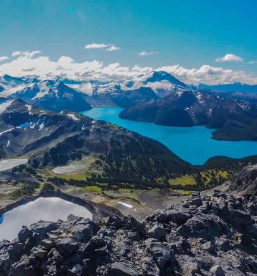 Lago com águas azuis cristalinas cercado por natureza exuberante para representar o seguro viagem Whistler.