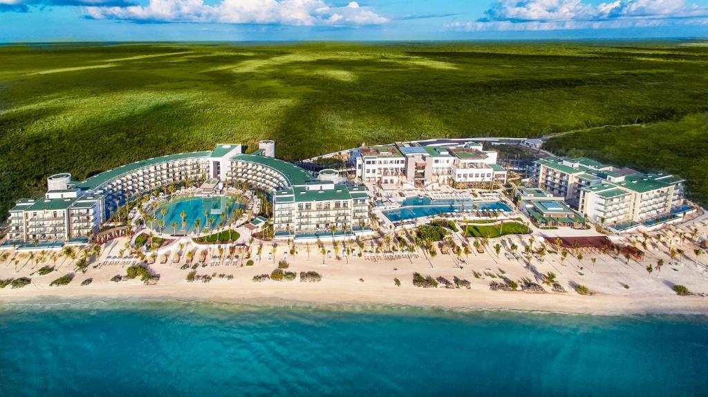 vista aerea do Haven Riviera Cancun com a praia na frente, a planície verde ao fundo e um céu azul no Haven Riviera Cancun
