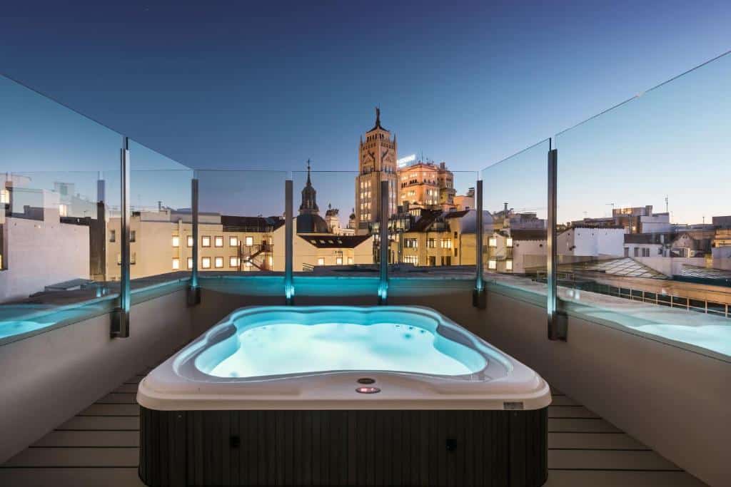 banheiro de hidro no terraço com vista da cidade e proteção de vidro no Catalonia Gran Vía Madrid um dos hotéis em Madri