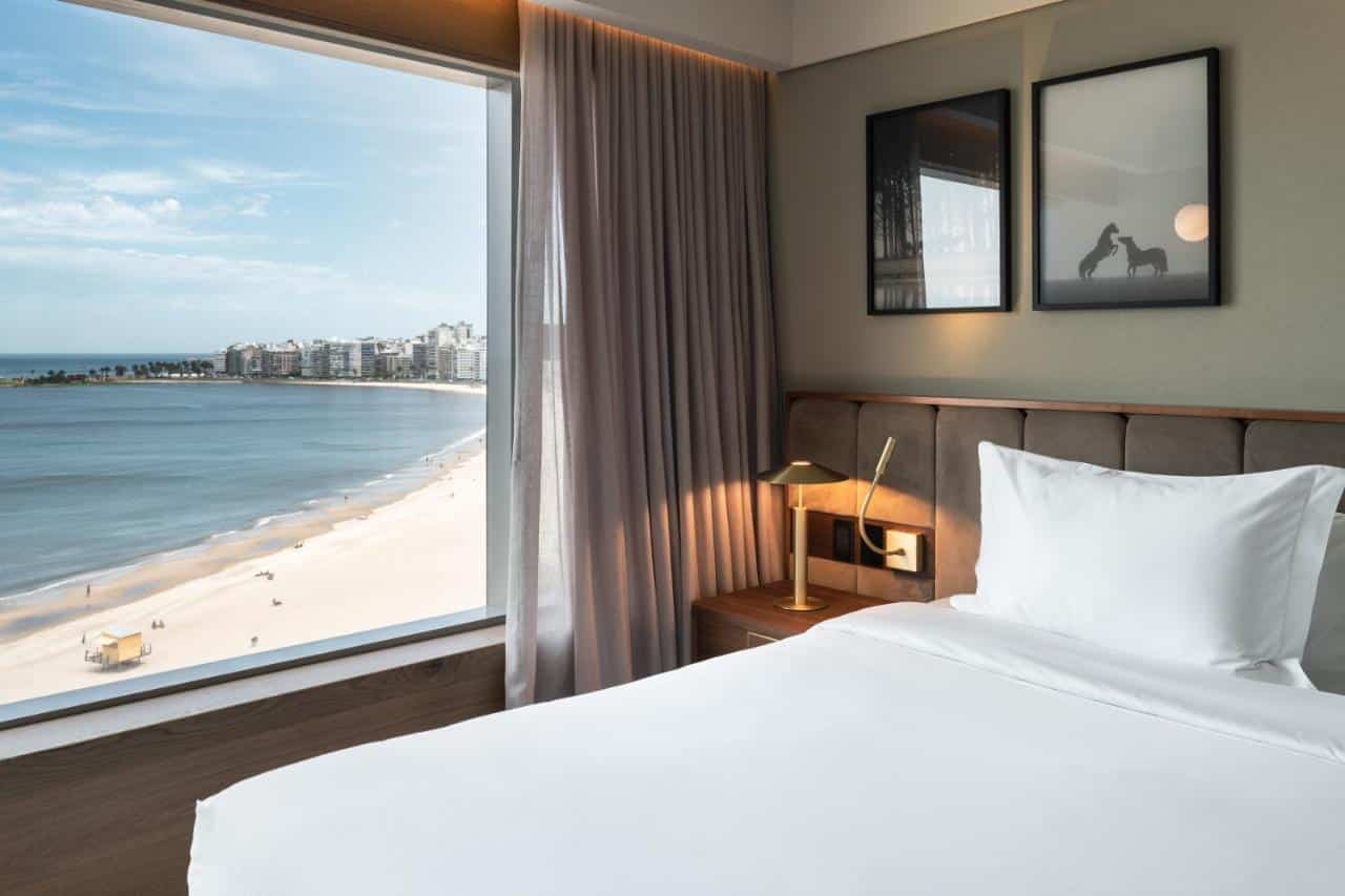 Quarto do Hotel Costanero Montevideo- MGallery com uma janela dando vista para a praia
