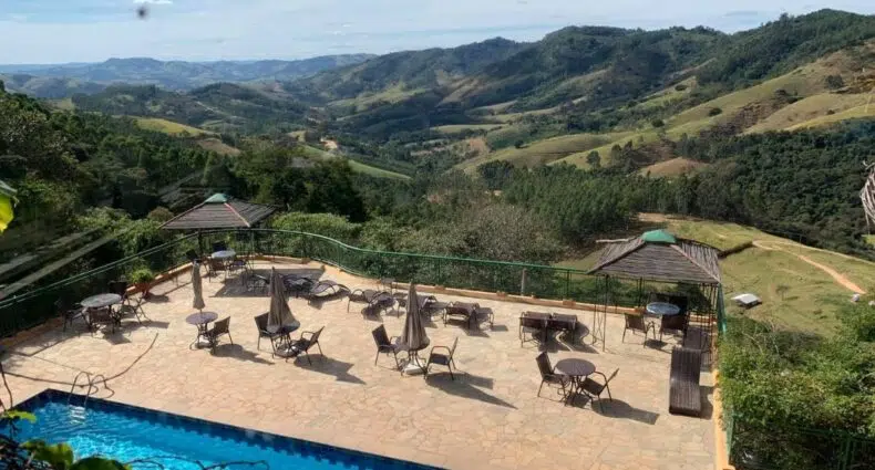 Piscina e deck do Hotel Pousada Shangri-la com vista para as montanhas