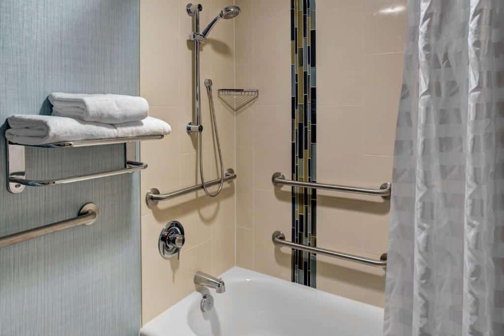 Banheiro adaptado do Hyatt Place Tampa Busch Gardens com barras de apoio e uma banheira