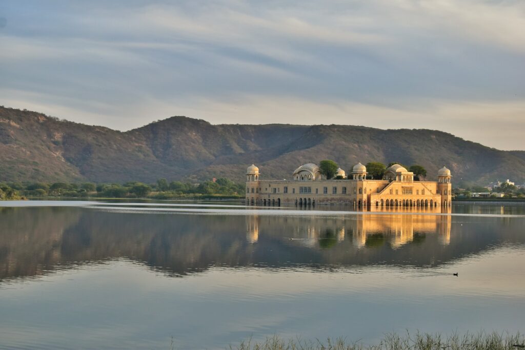 Construção branca de concreto no meio de um lago. É o Jaj Mahal, para ilustrar o seguro viagem Jaipur. - Foto: Vishal Daryani via Unsplash