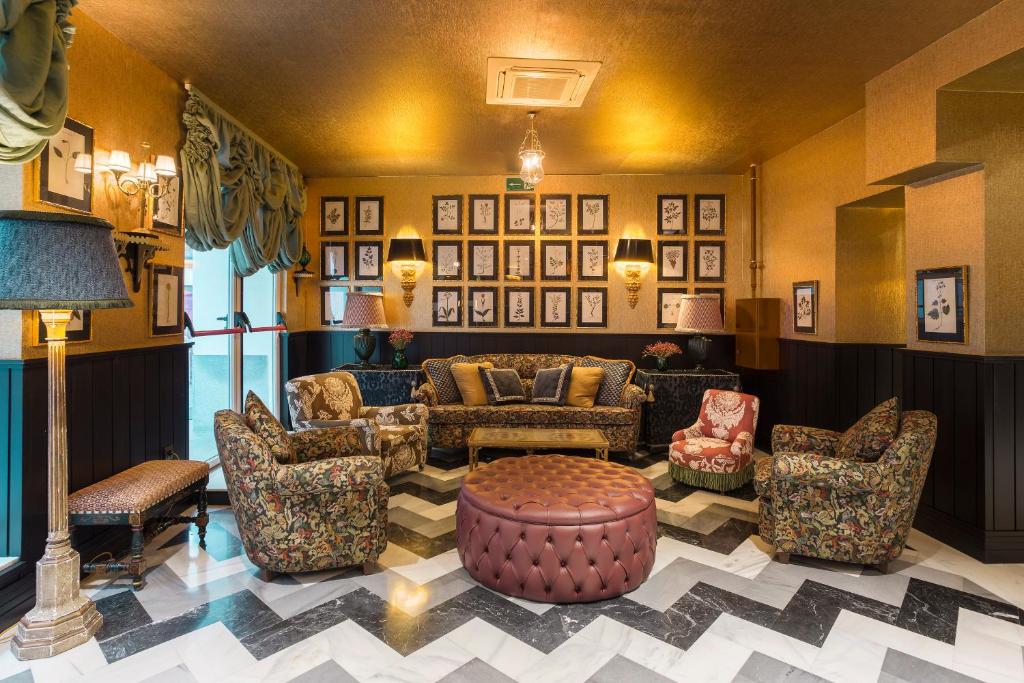 lounge com sofás, poltronas e muitos quadros com muitas cores e texturas do Room Mate Alba um dos hotéis em Madri