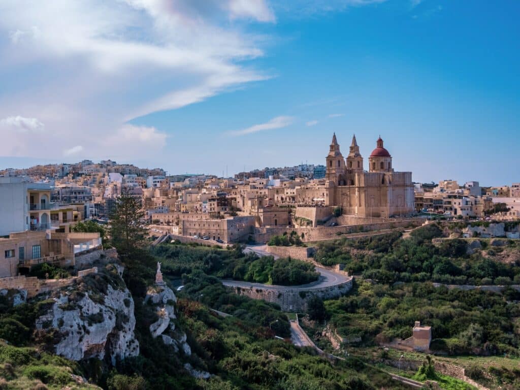 Mellieha em Malta um local cercado por rochas, muito verde e construções históricas
