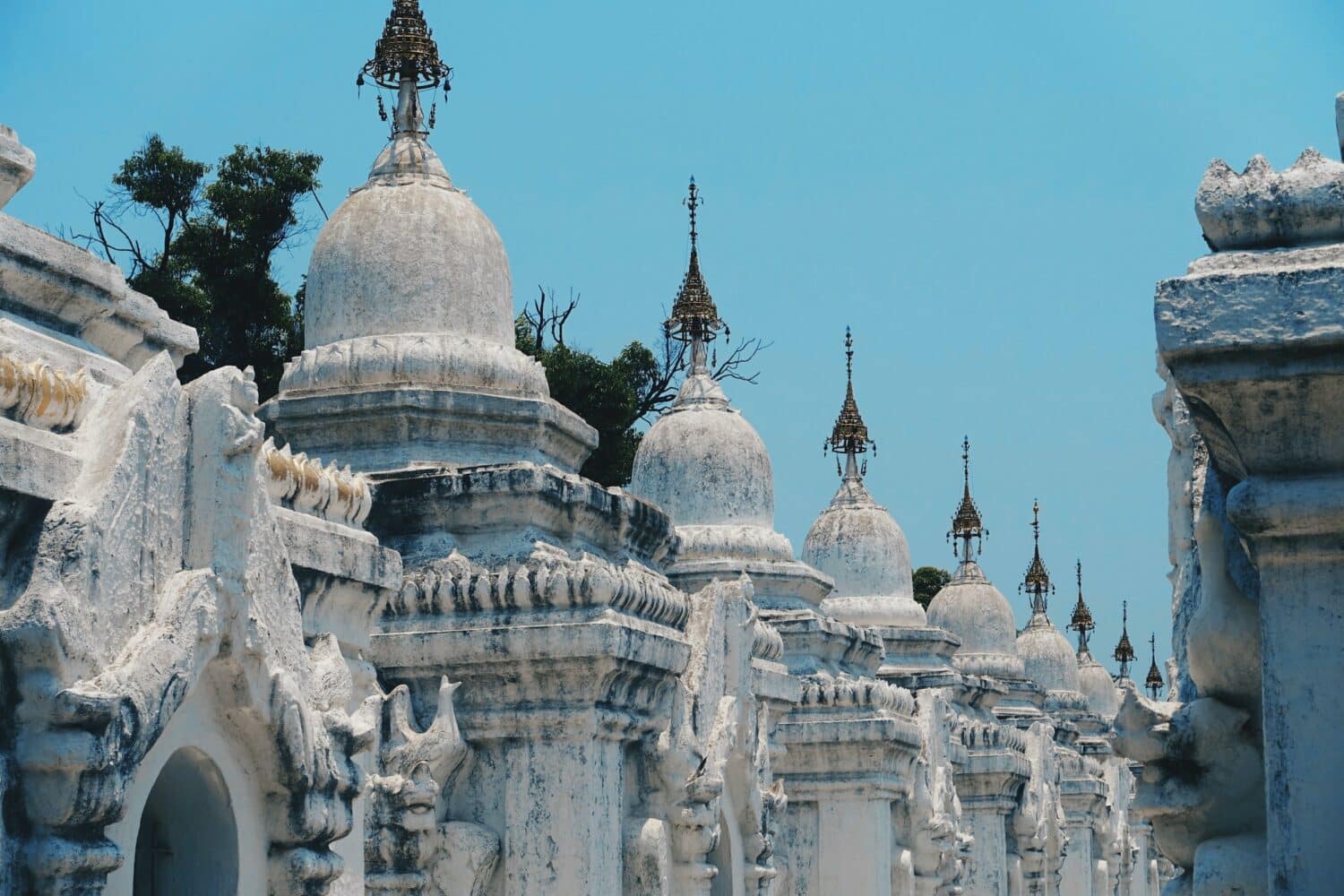 vista do Pagode de Kuthodaw em detalhes brancos e céu azul que pode ser visitado com o seguro viagem Myanmar