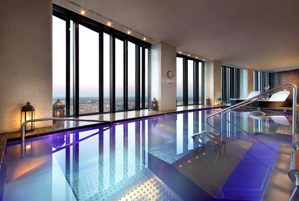piscina interna com vista refletindo nas águas no Eurostars Madrid Tower um dos hotéis em Madri