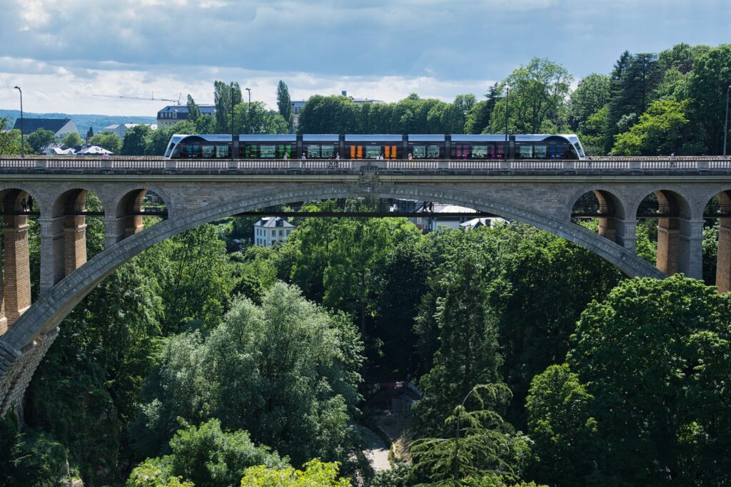 Ponte Adolphe em luxemburgo com o trem passando em cima e árvores em volta durante o dia