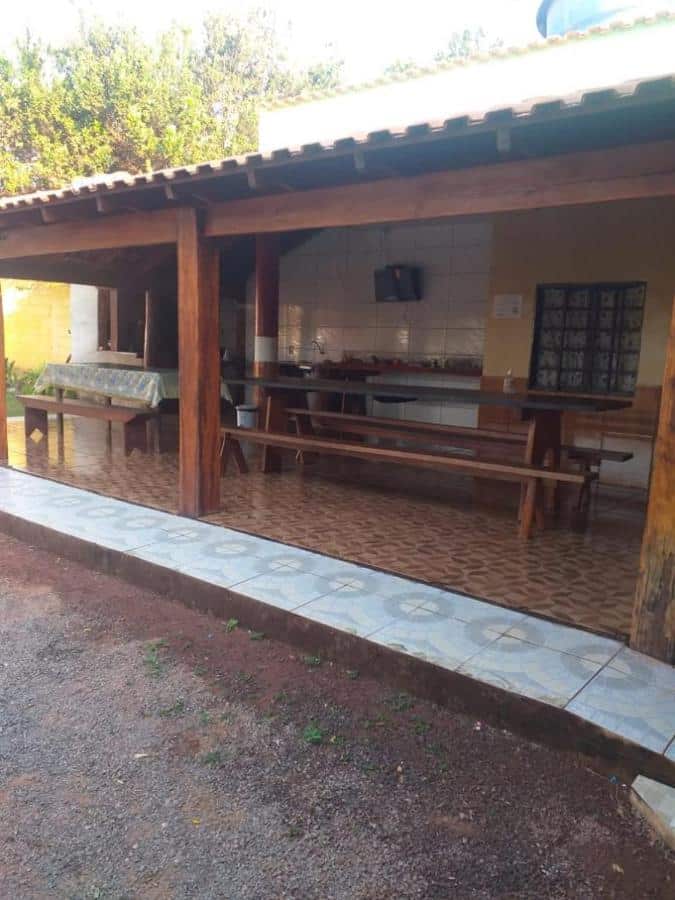 Área aberta, porém com cobertura, mesas e bancos de piquenique, na Pousada Mato Grosso, uma das pousadas em Nobres