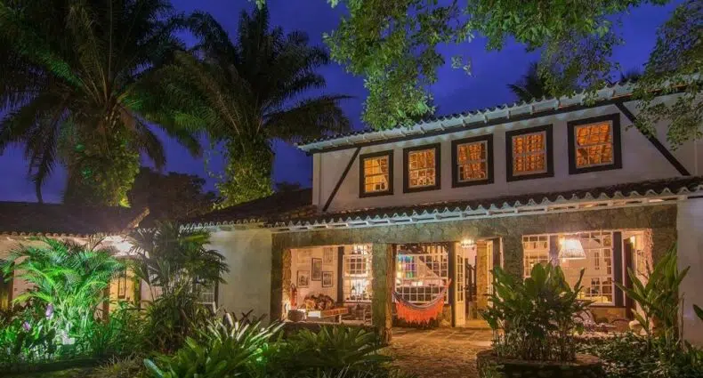 Fachada da Pousada Pardieiro de noite com as luzes acesas e muita vegetação ao redor