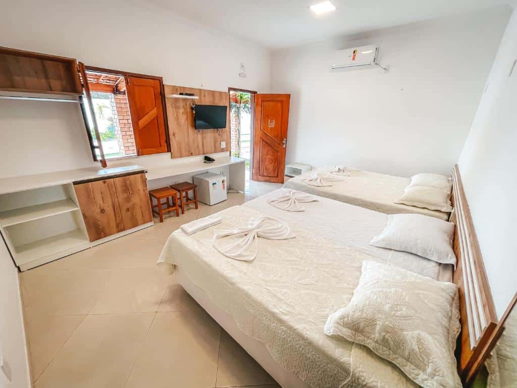 Quarto da Pousada Vasto Horizonte, com duas camas de casal, ar-condicionado, TV, frigobar e pequenos armários