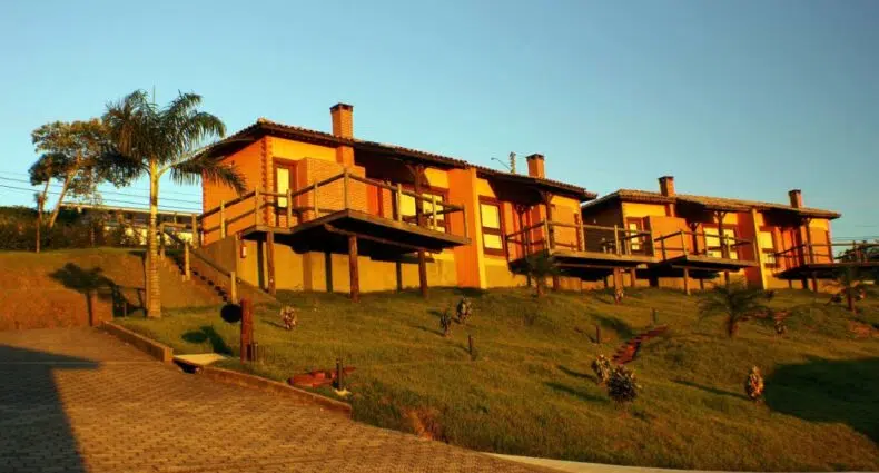 Pousadas Villa dos Leais com diversos chalés um do lado do outro com natureza ao redor e a construção é em madeira