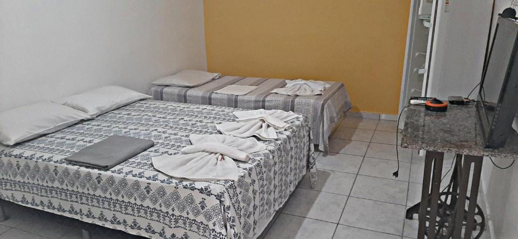 Quarto com cama de casal e cama de solteiro na Pousadas Portal das Araras. 