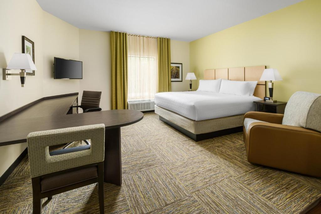quarto amplo com cama, mesa de trabalho e poltrona no Candlewood Suites - Orlando - Lake Buena Vista, an IHG Hotel um dos hotéis com cozinha em Orlando