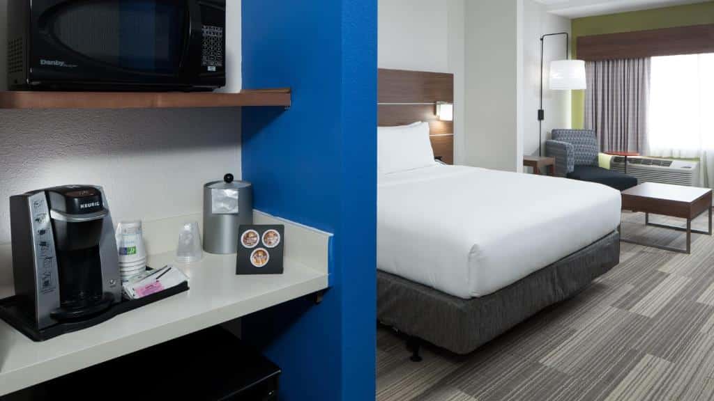 quarto com janela e cama de casal, com uma divisória com prateleiras, com micro-ondas e cafeteira no Holiday Inn Express & Suites - Orlando At Seaworld, an IHG Hotel