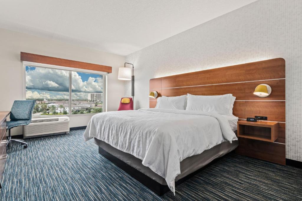 quarto com cama de casal e vista com céu no Holiday Inn Express & Suites Orlando- Lake Buena Vista, an IHG Hotel