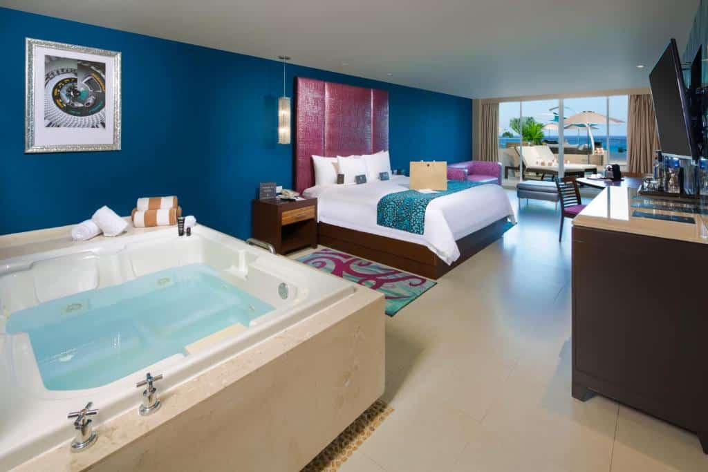 quarto do Hard Rock Hotel com uma banheira de hidromassagem, uma cama de casal, uma área de estar e uma varanda particular ao fundo