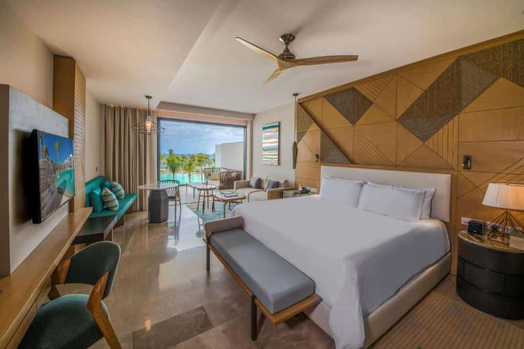 quarto com cama de casal, sala de estar e sacada privativa no Haven Riviera Cancun