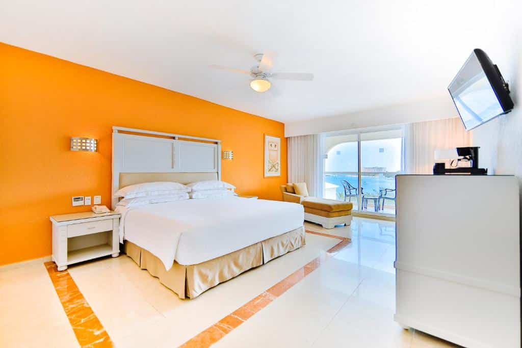 quarto do Occidental Costa com uma cama de casal e uma varanda particular com vista para o mar