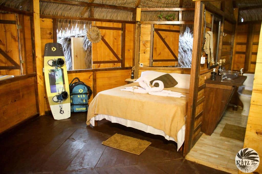 Quarto do Raiz Kite Cabana com cama ampla e ambiente rustico.