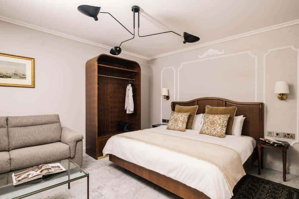 Quarto do The Gomerino Hotel com uma cama de casal, um armário de conceito aberto, um sofá, uma mesinha de centro, tudo decorado em um estilo mais vintage e com madeira envelhecida