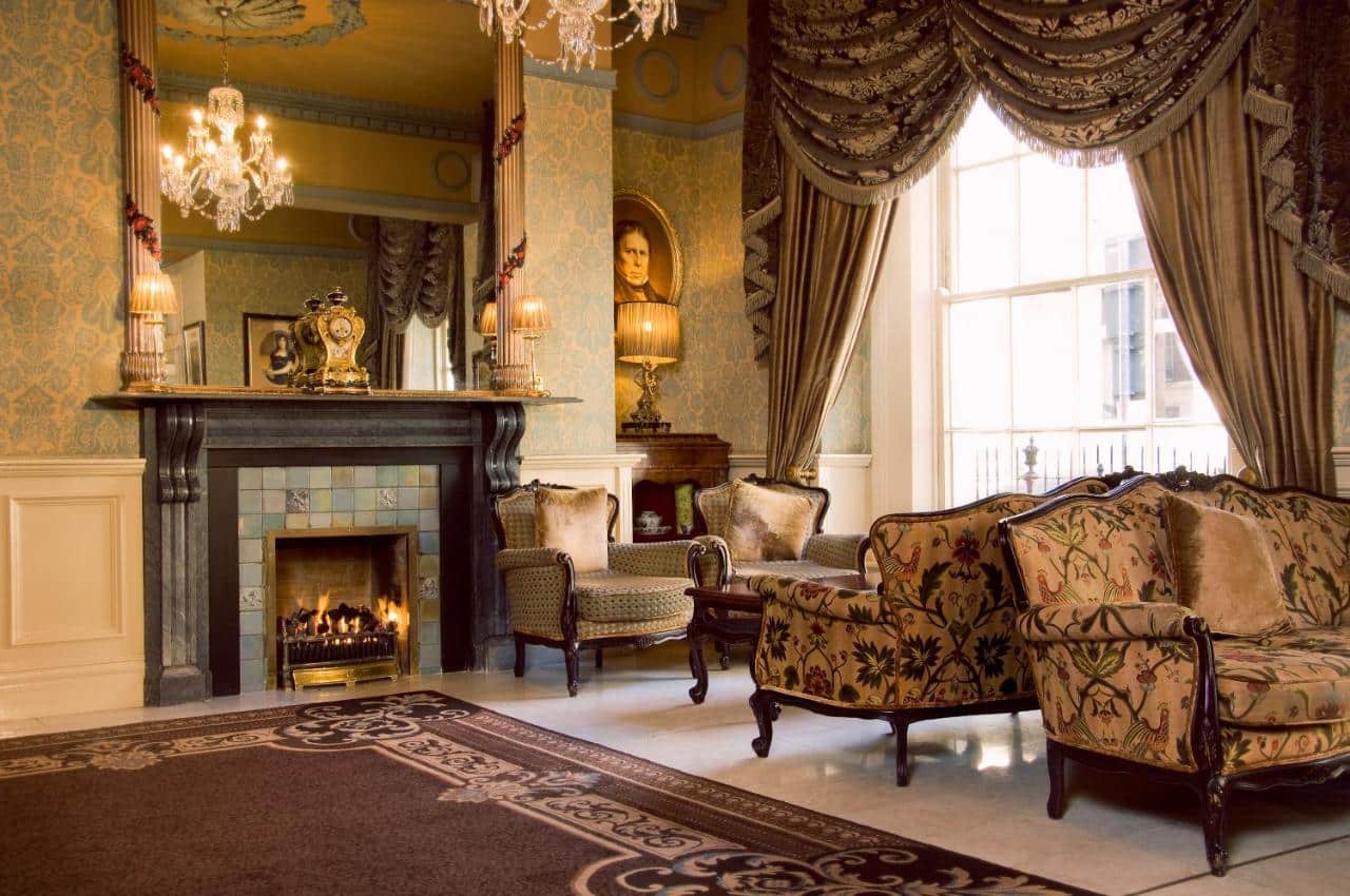 Sala com lareira e duas poltronas tudo em estilo vitoriano no Buswells Hotel em Dublin